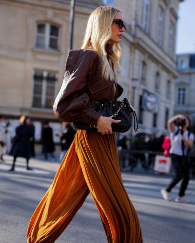 Leonie Hanne wears a contemporary brown dress with pleats.