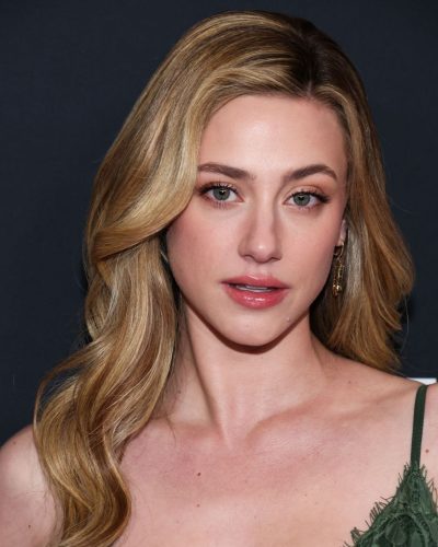 Lili Reinhart in green dress with subtle smile and relaxed demeanor.