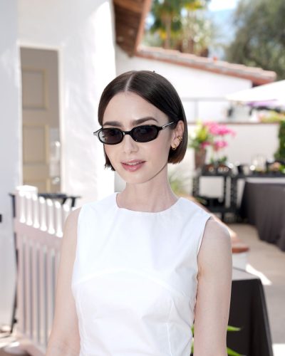 Lily Collins styled in a white mini dress and black flip-flops