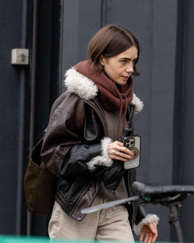 Lily Collins in light-colored trousers paired with brown boots