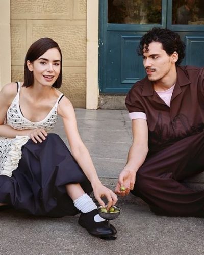 Lily Collins styled in a lightweight dress featuring lavender and pink hues.