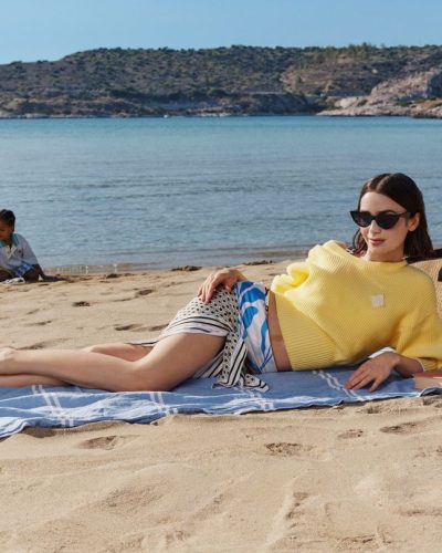 Lily Collins in a vibrant summer dress with flowing fabric.