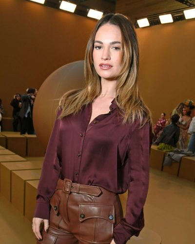 Lily James in maroon coat and tailored leather trousers
