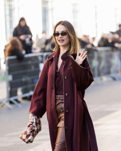 Lily James in rich maroon blouse and fitted leather pants