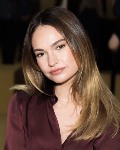 Lily James in deep maroon blouse and tailored leather trousers