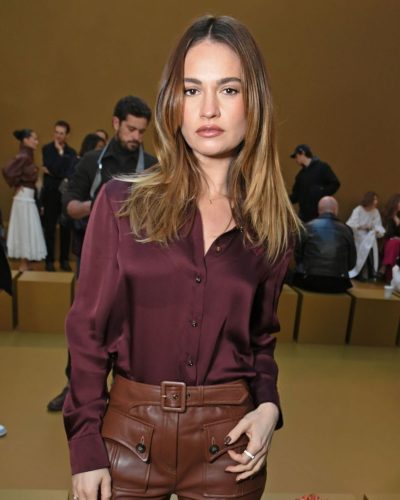 Lily James in sophisticated maroon blouse and leather pants