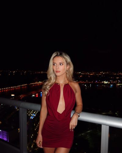 Lindsay Brewer in a burgundy dress with a striking neckline.