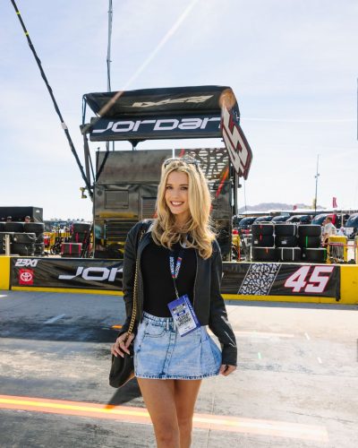 Lindsay Brewer wearing a stylish burgundy gown with unique neckline.