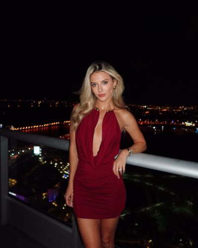 Lindsay Brewer in a vibrant burgundy dress with a plunging neckline.