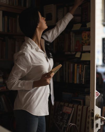 Liza Makhu wearing a button-up white shirt and blue jeans.