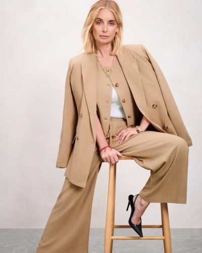 Louise Redknapp wearing a chic brown shirt with cream pants.