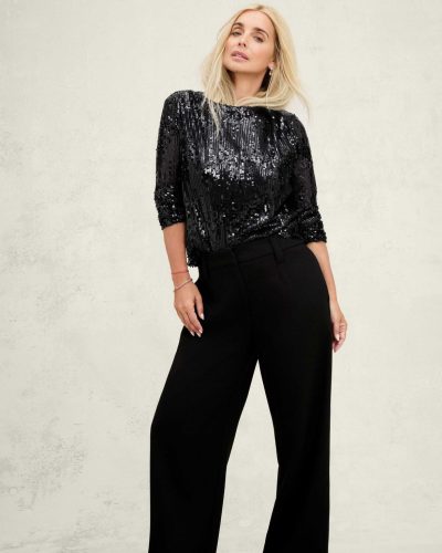 Louise Redknapp in brown belted shirt and cream trousers.