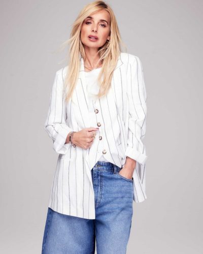 Louise Redknapp sporting a brown shirt and light cream trousers.