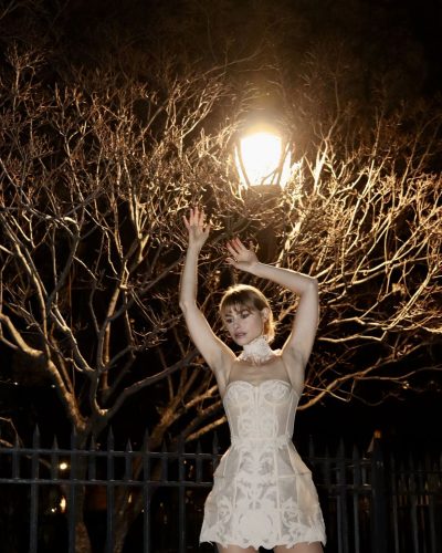 Lucy Fry light-colored dress with intricate craftsmanship