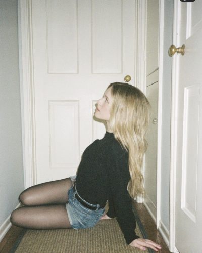 Lulu Wilson sporting a classic black top and denim shorts.