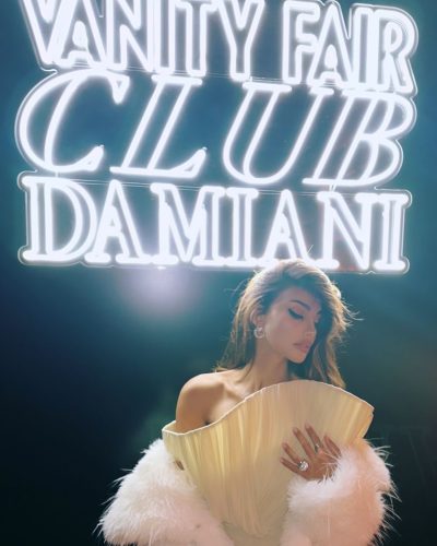 Madalina Ghenea in minimal white bikini against ocean backdrop.