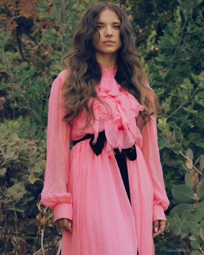Madeleine McGraw in light pink ruffled blouse and chic skirt