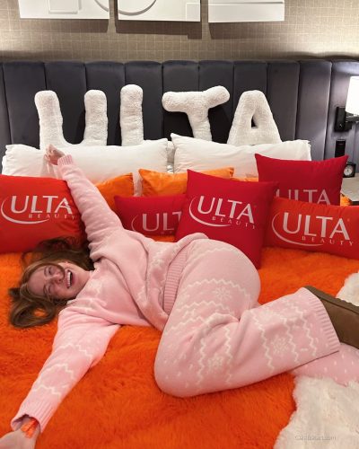 Madeline Ford in playful pink sweater and chic fluffy boots.