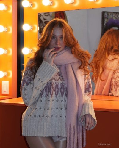 Madeline Ford wearing light pink sweater and trendy winter footwear.