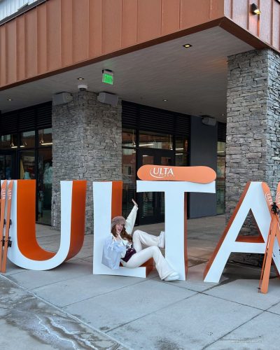 Madeline Ford in playful pink sweater and chic fluffy boots.