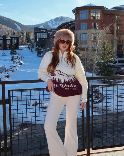 Madeline Ford with vibrant pink sweater layered over fitted attire.