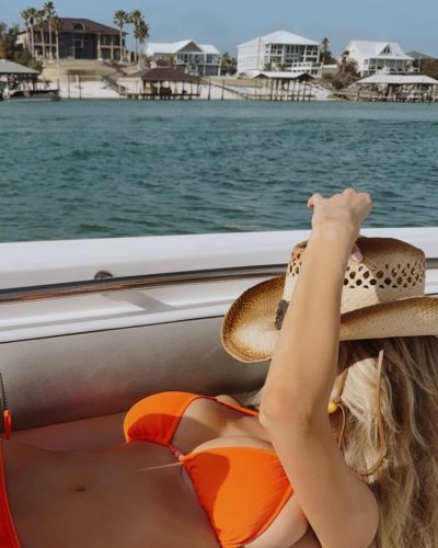 Madeline Hope in a colorful orange bikini by the shore