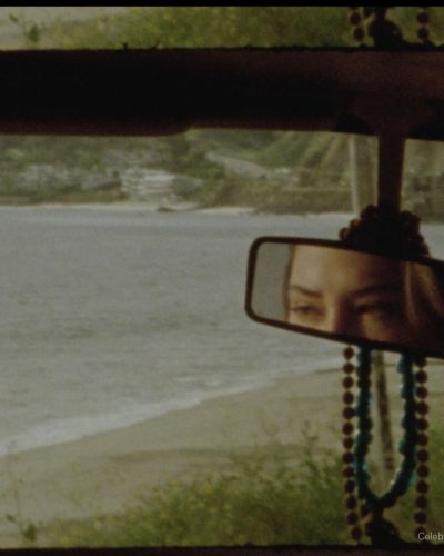 Madelyn Cline wearing a vibrant red shirt and white shorts.