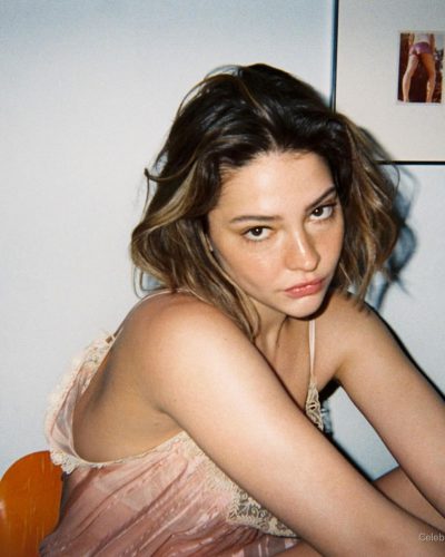 Madelyn Cline in a vibrant red shirt and tailored white shorts.