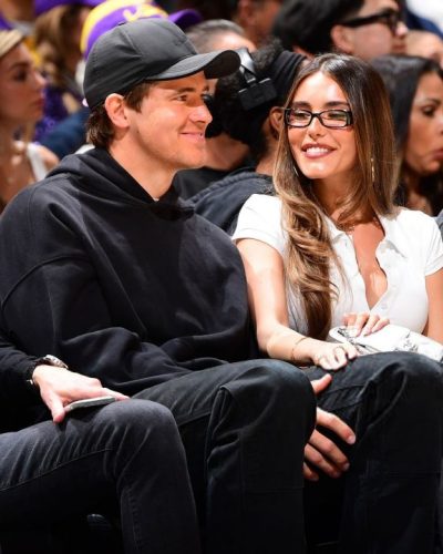 Madison Beer in a white top and relaxed light blue jeans.