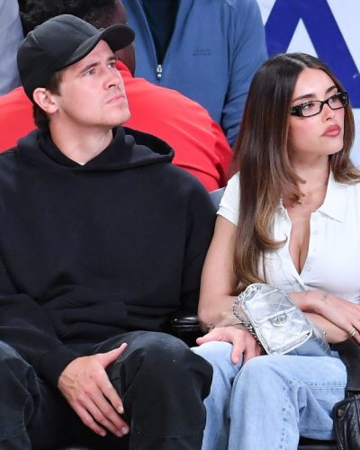 Madison Beer wearing a white button-up and light blue denim pants.