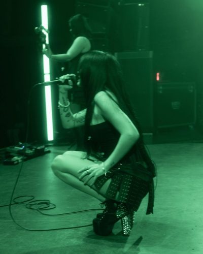 Maggie Lindemann wearing fitted black dress and striking silhouette.