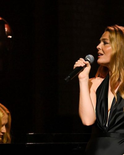 Maggie Rogers in black dress with dramatic stage presence.