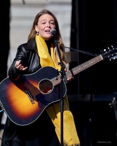 Maggie Rogers black leather jacket and yellow scarf combination