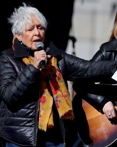 Maggie Rogers vibrant yellow scarf with black leather jacket