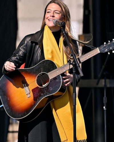 Maggie Rogers black leather jacket with statement earrings