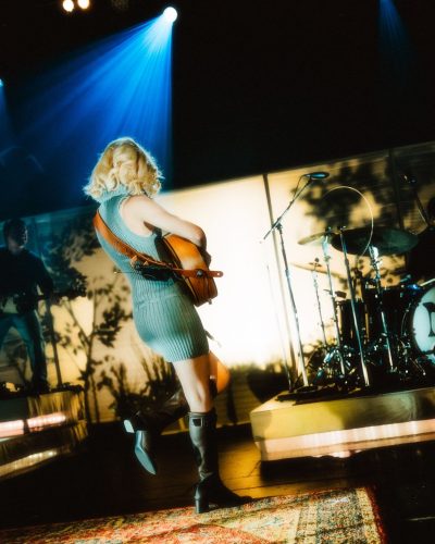 Maisie Peters in a chic ribbed mini dress paired with black boots.