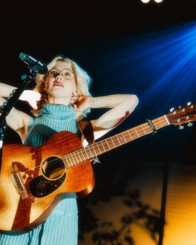 Maisie Peters in a ribbed high-neck dress paired with edgy black boots.