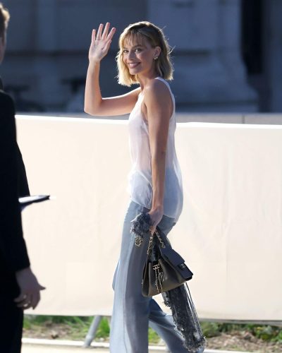 Margot Robbie vibrant yellow background enhancing her attire.