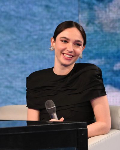 Matilda De Angelis chic black dress with ruffled elements and dark heels