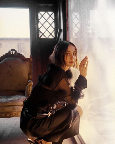 Maude Apatow with a flower necklace paired with a black dress.