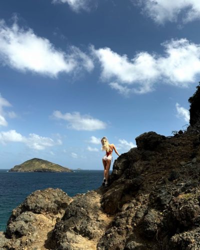 McKenzie Hewson accessorized with sunglasses in bright red gown