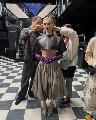 Meg Donnelly fitted leather top, wide-leg beige trousers, purple gloves