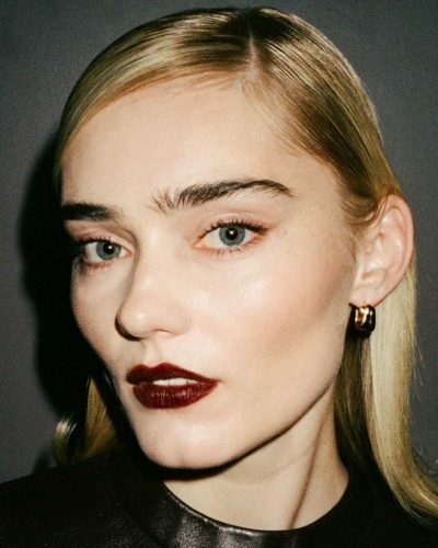 Meg Donnelly cropped leather top, billowy beige trousers, bold purple gloves