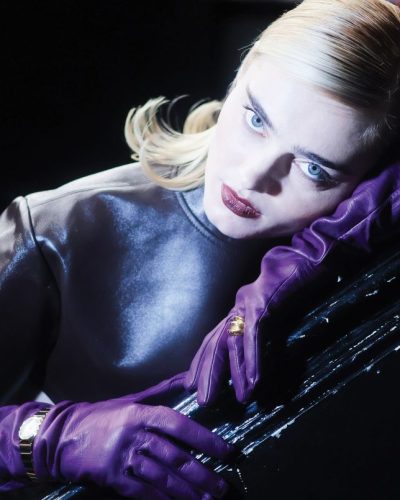 Meg Donnelly leather top, beige trousers, vibrant purple gloves