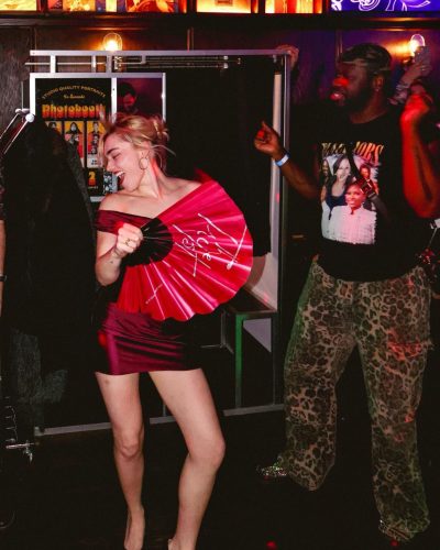 Meg Donnelly in a satin deep red gown with bold lips.