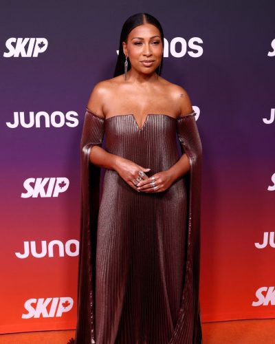 Melanie Fiona in a floor-length bronze gown with pleated details