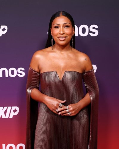 Melanie Fiona wearing a chic pleated gown in shimmering bronze