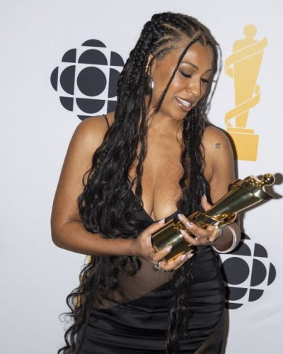 Melanie Fiona in a black gown with sheer panels