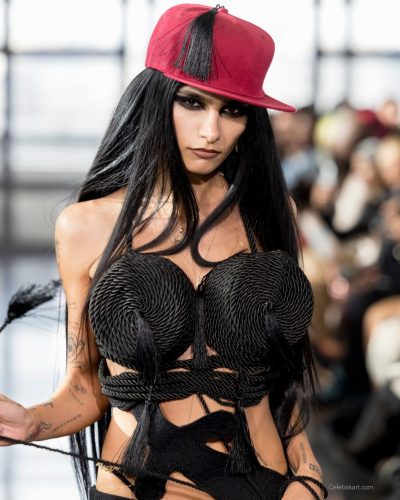 Mia Khalifa black dress with bold metallic accents and silver boots