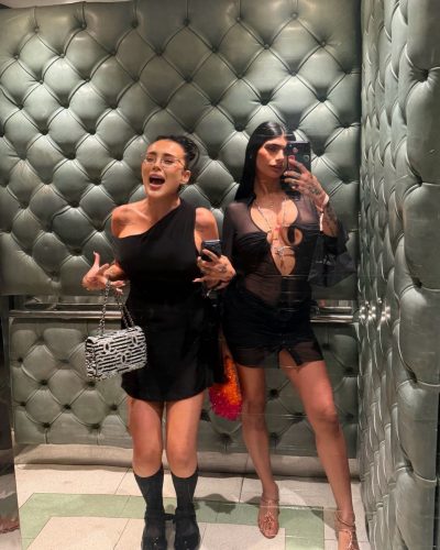 Mia Khalifa sporting a white mini dress with fashionable black flats.